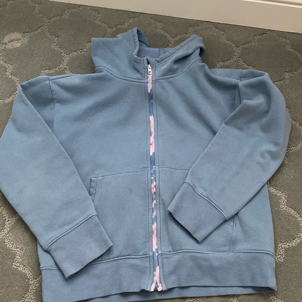 This is a used athleta girl zip up hoodie. There is only 1 noticeable stain.